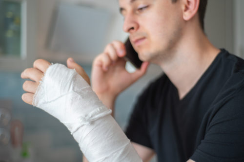  man calling his lawyer after surgery on his wrist.