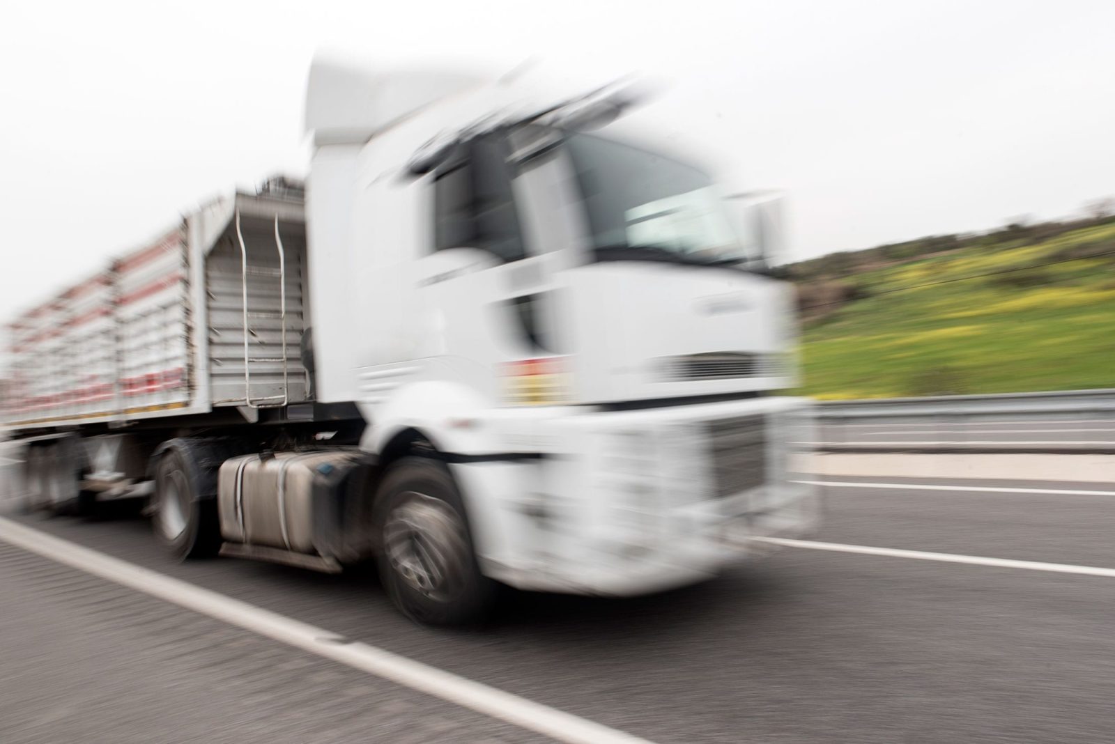 White Semi-Truck Driving On A Highway Stock Photo