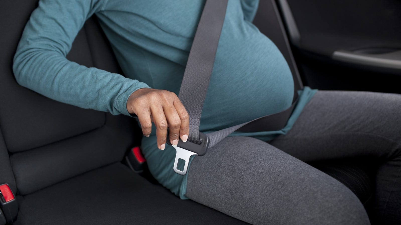 Pregnant Woman Fastening Seat Belt Stock Photo