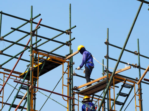 A construction worker standing on scaffolding