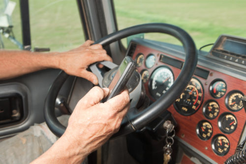 A truck driver texting and driving.