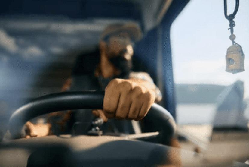 A man operating a large truck. Review six questions to ask your truck accident lawyer.