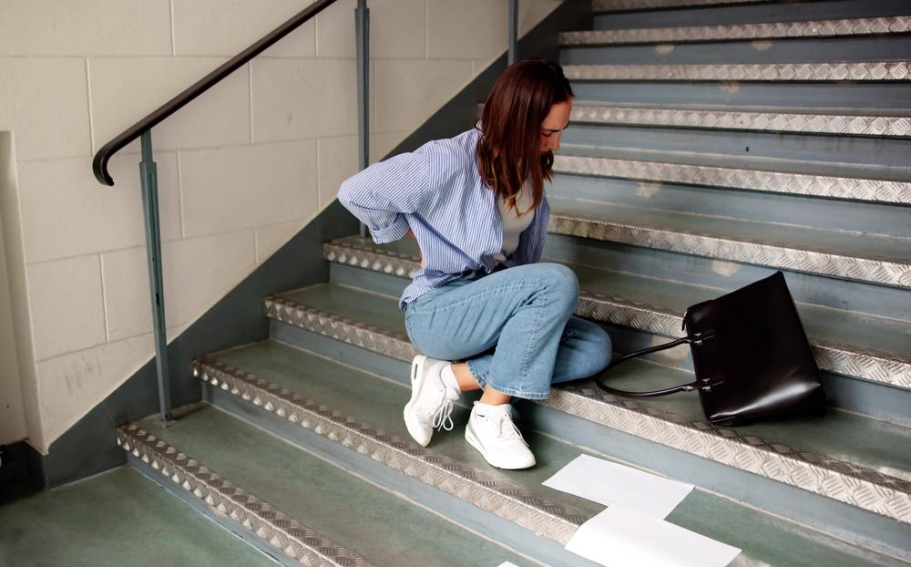 A woman sitting down after a fall. A lawyer can explain how slip and fall accident settlements are calculated. 
