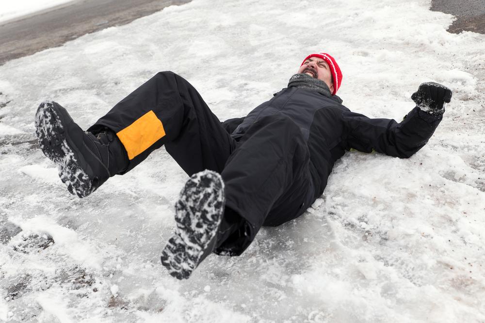 A man lies on the ice after a fall, wondering how to prove a slip-and-fall case. 