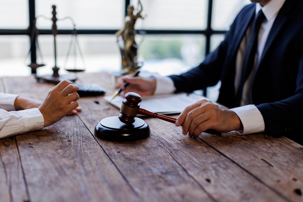 A man speaking to a lawyer. Go over x questions to ask your personal injury lawyer.